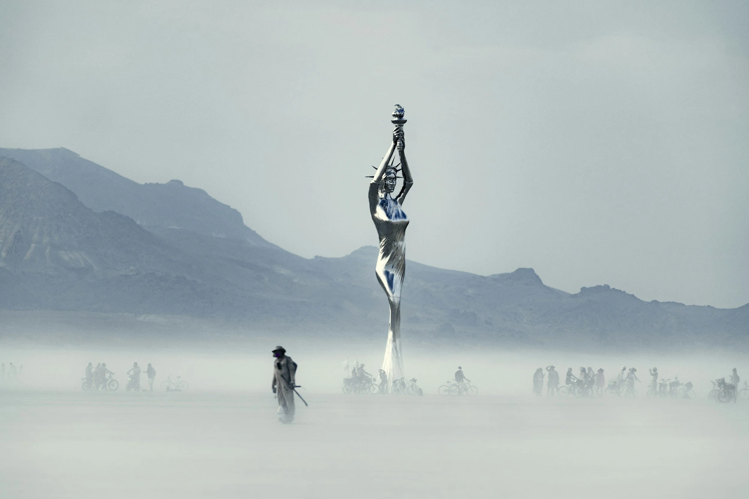 A sculpture of the Statue of Liberty in a foggy landscape with mountains in the background, surrounded by people and bicycles, some wearing protective gear. Declaring a win and victory.