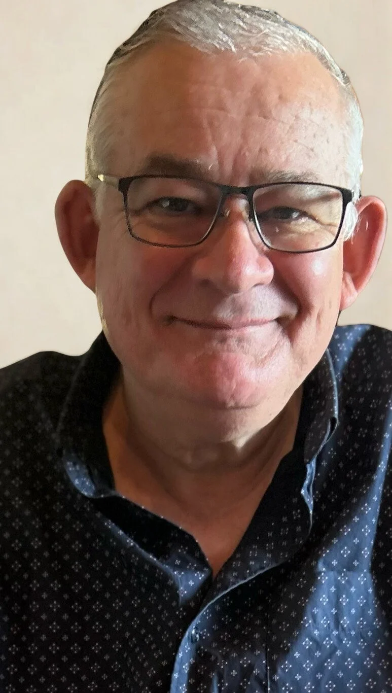 Smiling person with glasses and a blue shirt