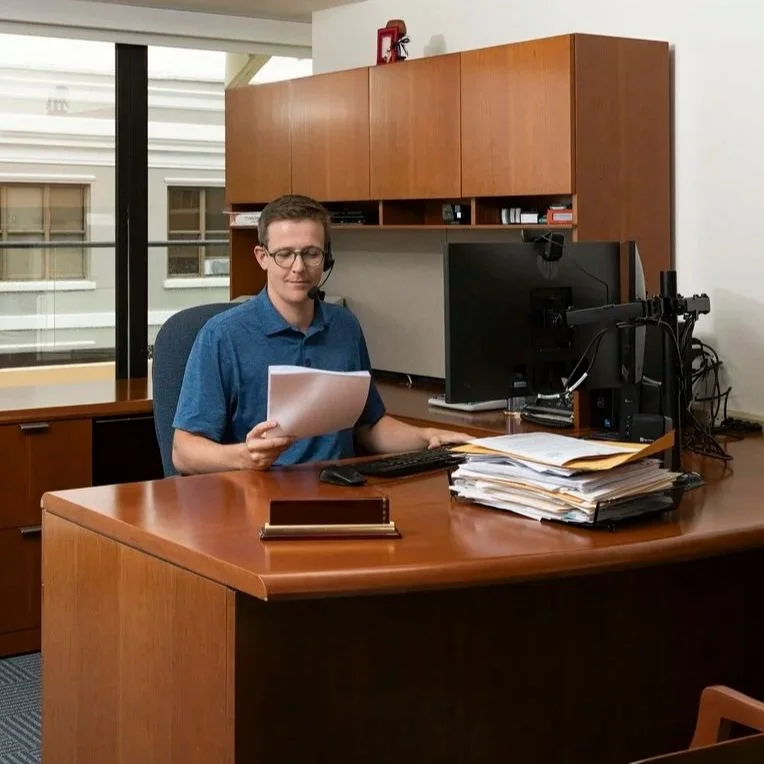 Empty office with wooden desk and cabinets near large window