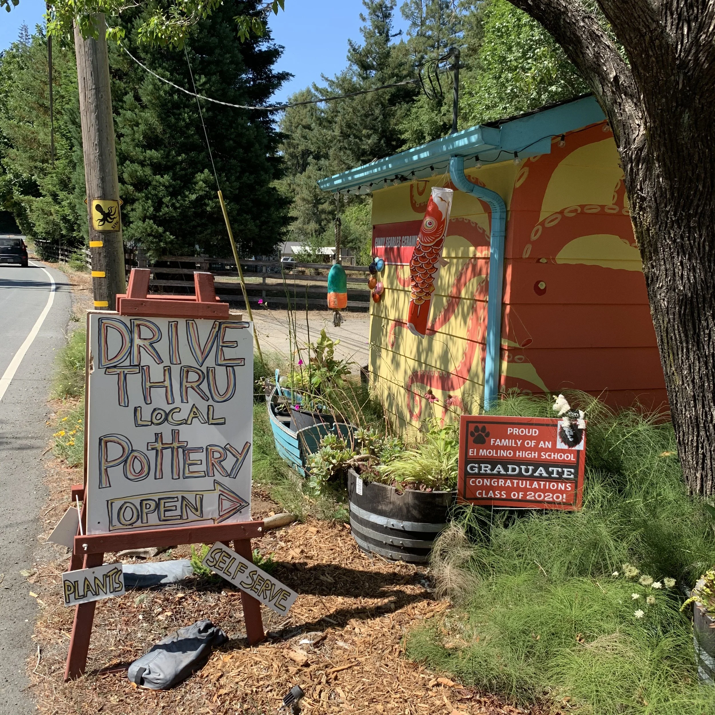 A sign directing people to the Drive Through Pottery Stand in Occidental, California