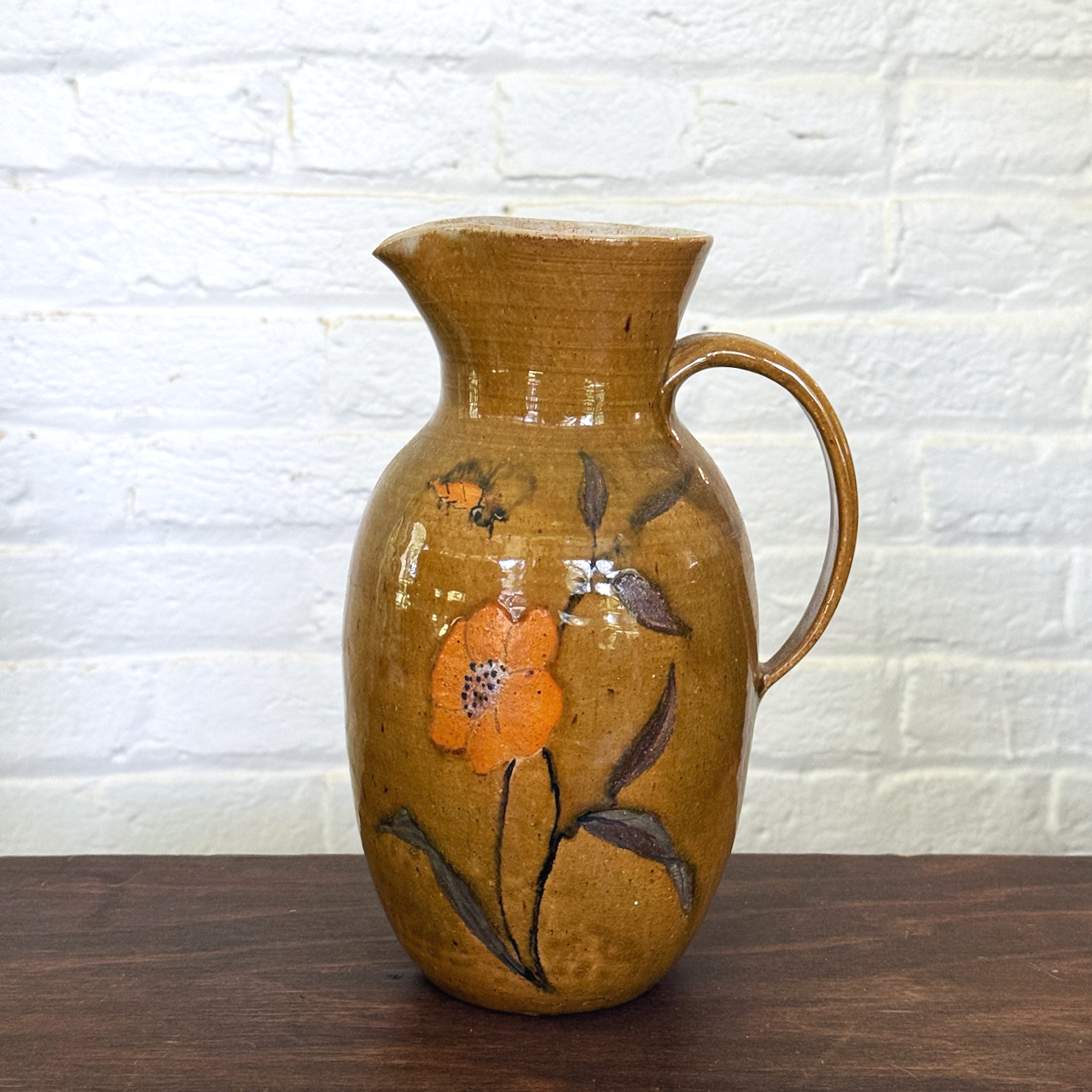 Artist-signed studio pottery vase with hand-painted floral decoration.