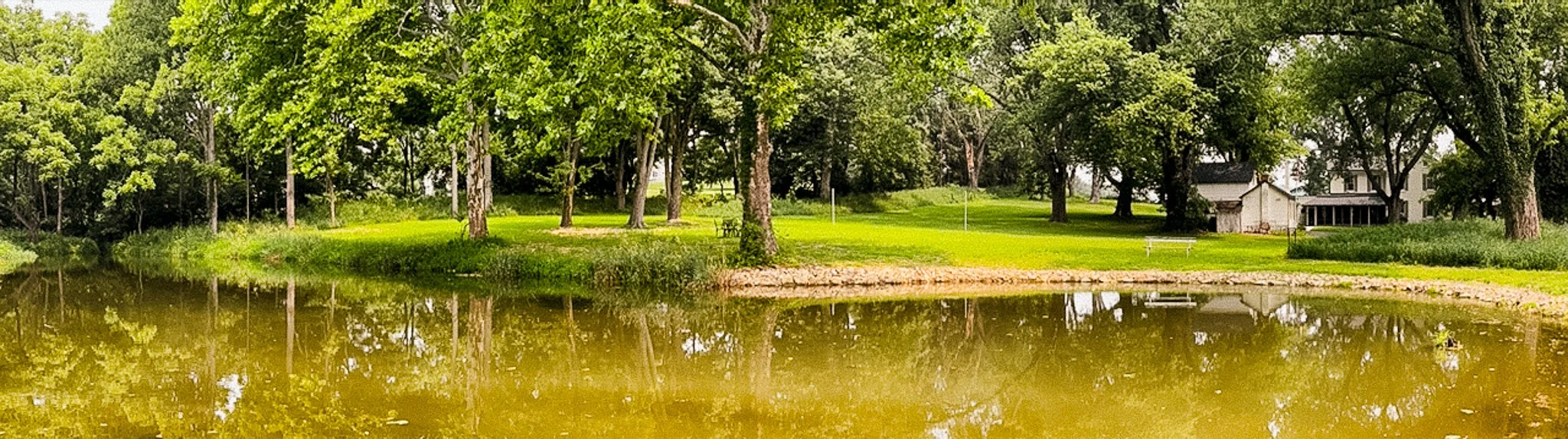 A pond in the country with an old house
