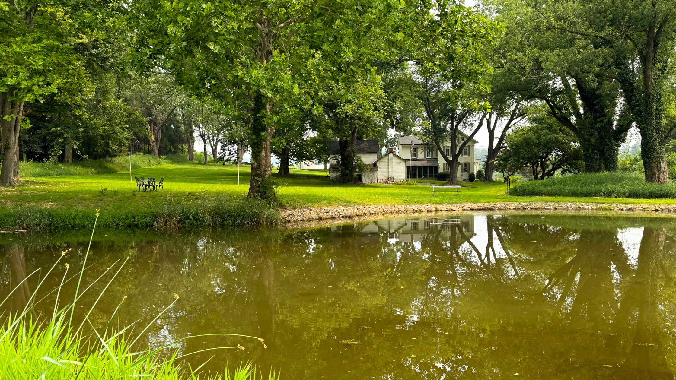 Bryter Pond property with pond, gardens, mature trees, and historic farmhouse.