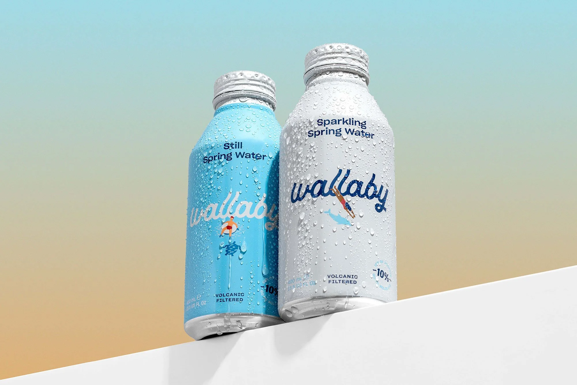 Two bottles of Wallaby spring water, one still and one sparkling, on a light surface with a gradient background.