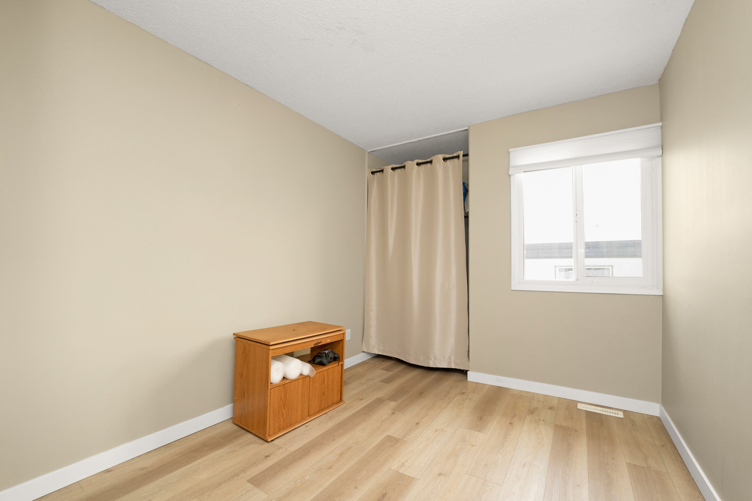 Minimalist room with a window and wooden flooring