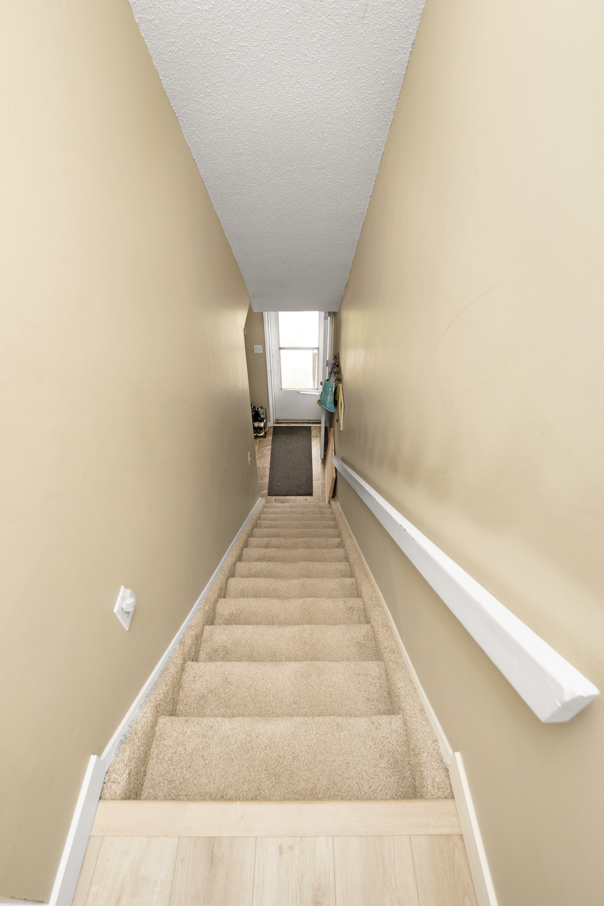 Unfinished basement with exposed beams and storage items.