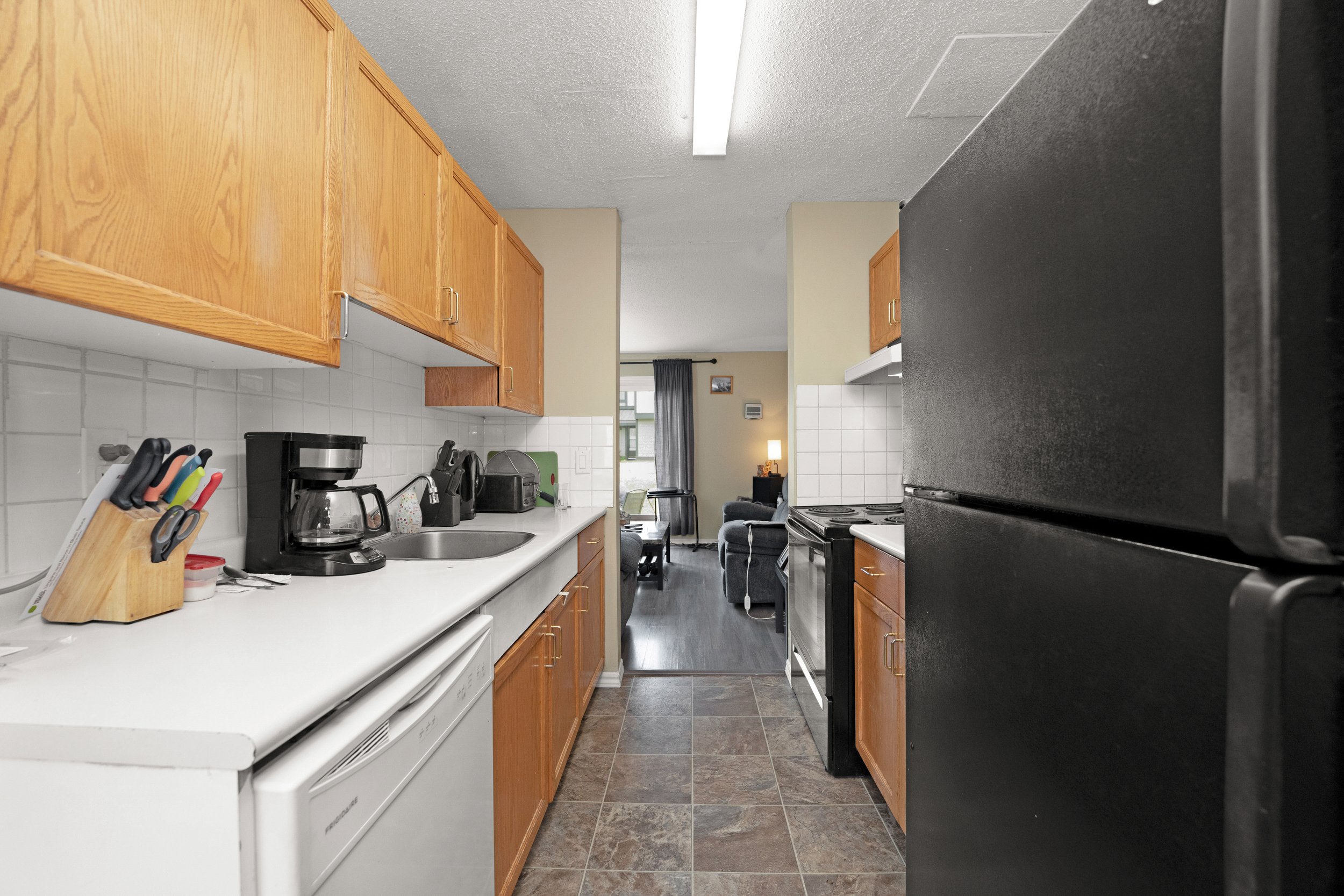 Well-lit kitchen interior with wooden cabinets and stove.
