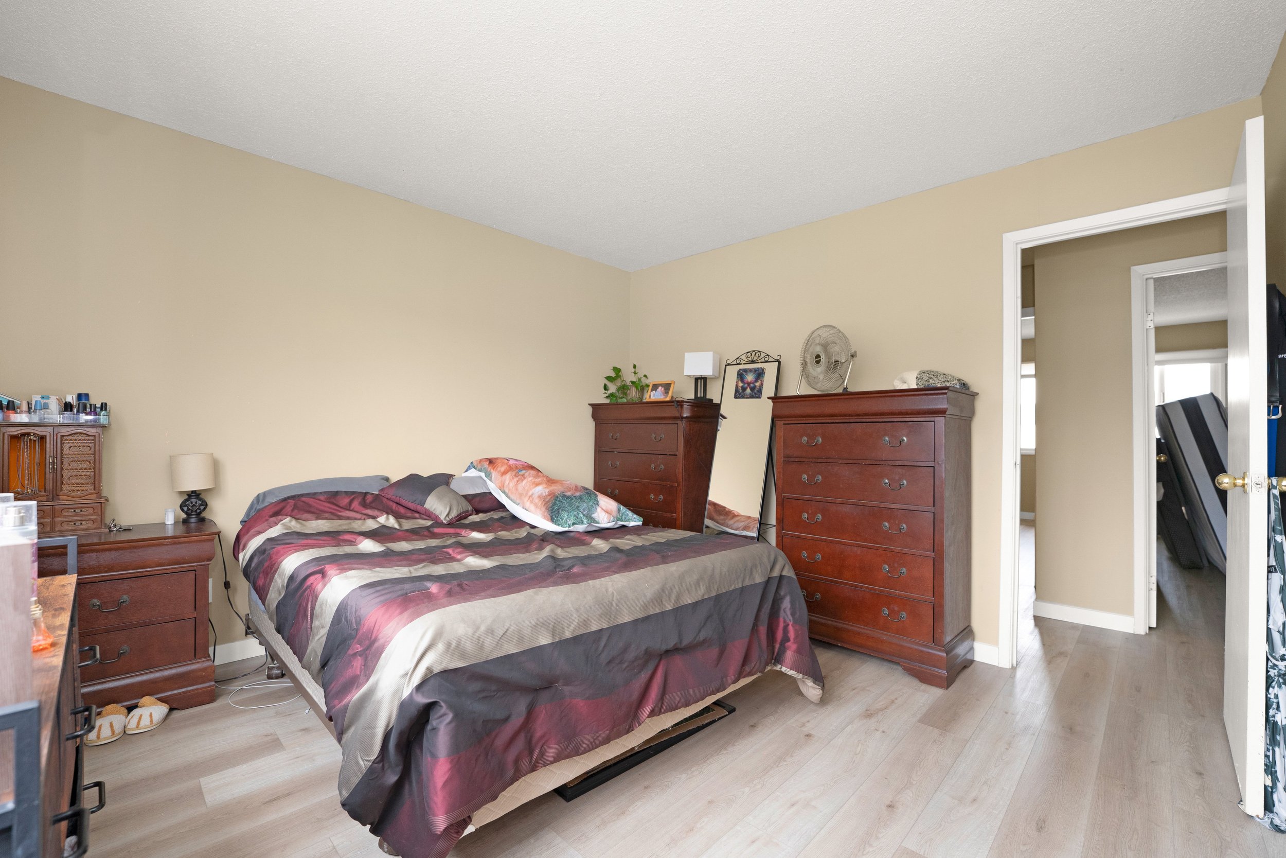 Comfortable bedroom with patterned bedding and storage.
