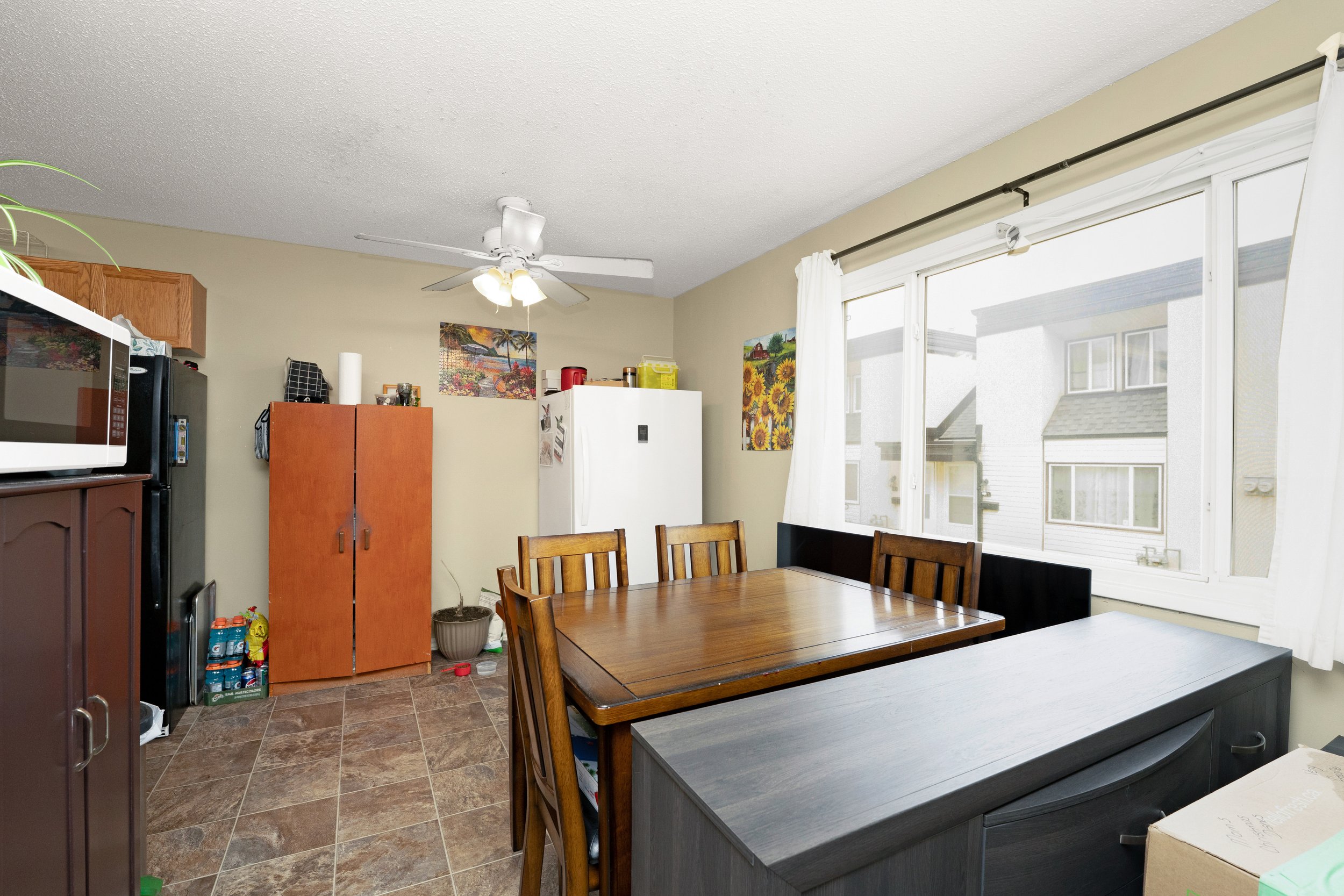Spacious dining area with a large table and ceiling fan.