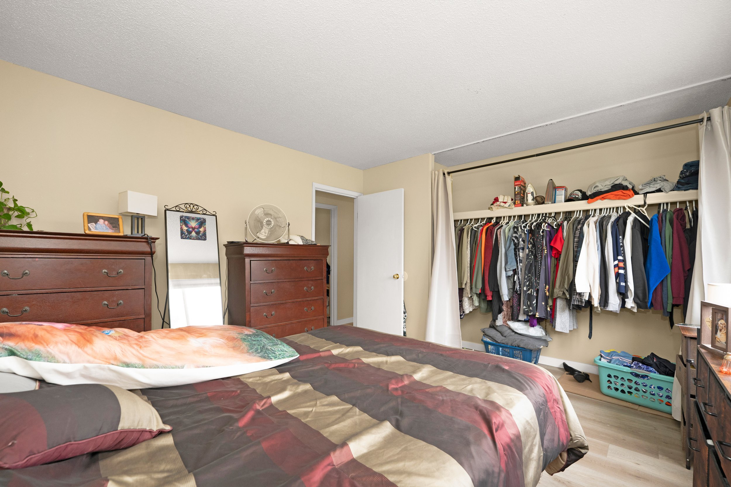 Cozy bedroom in a rent to own home with patterned bedding and closet.