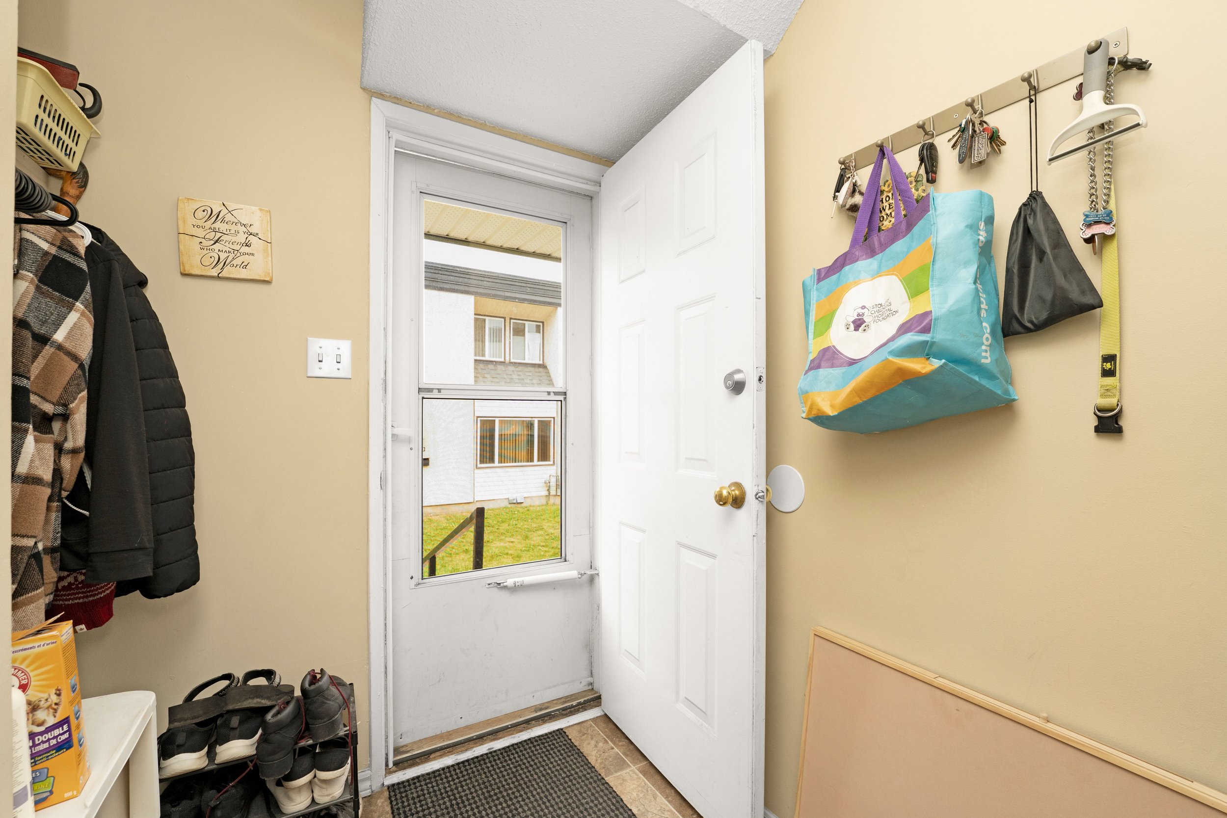 Bright front door of a home with decorative porch elements.