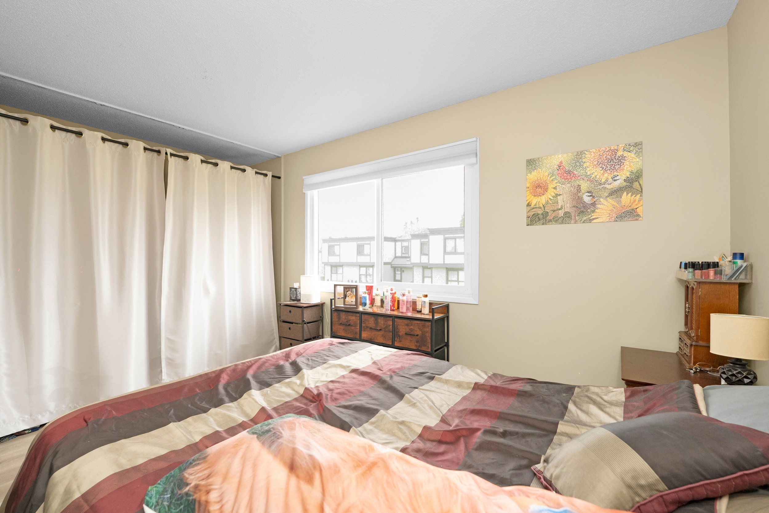 Bright bedroom with a comfortable bed and neutral decor.