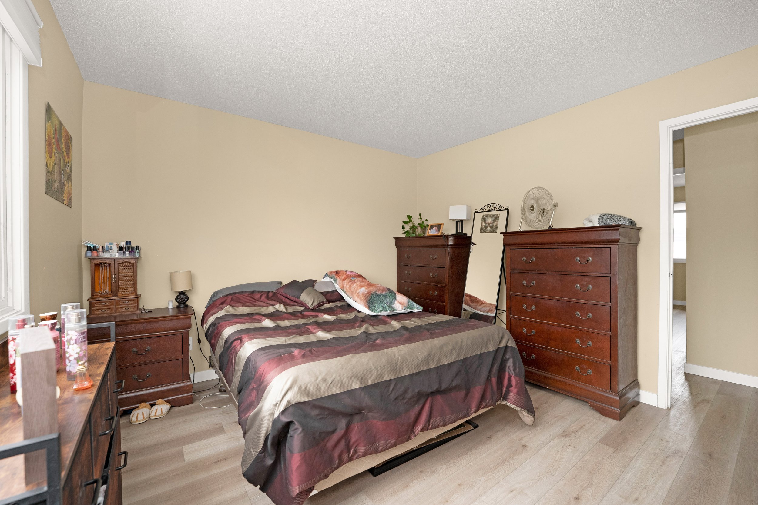 Warm bedroom featuring twin beds and a dresser.