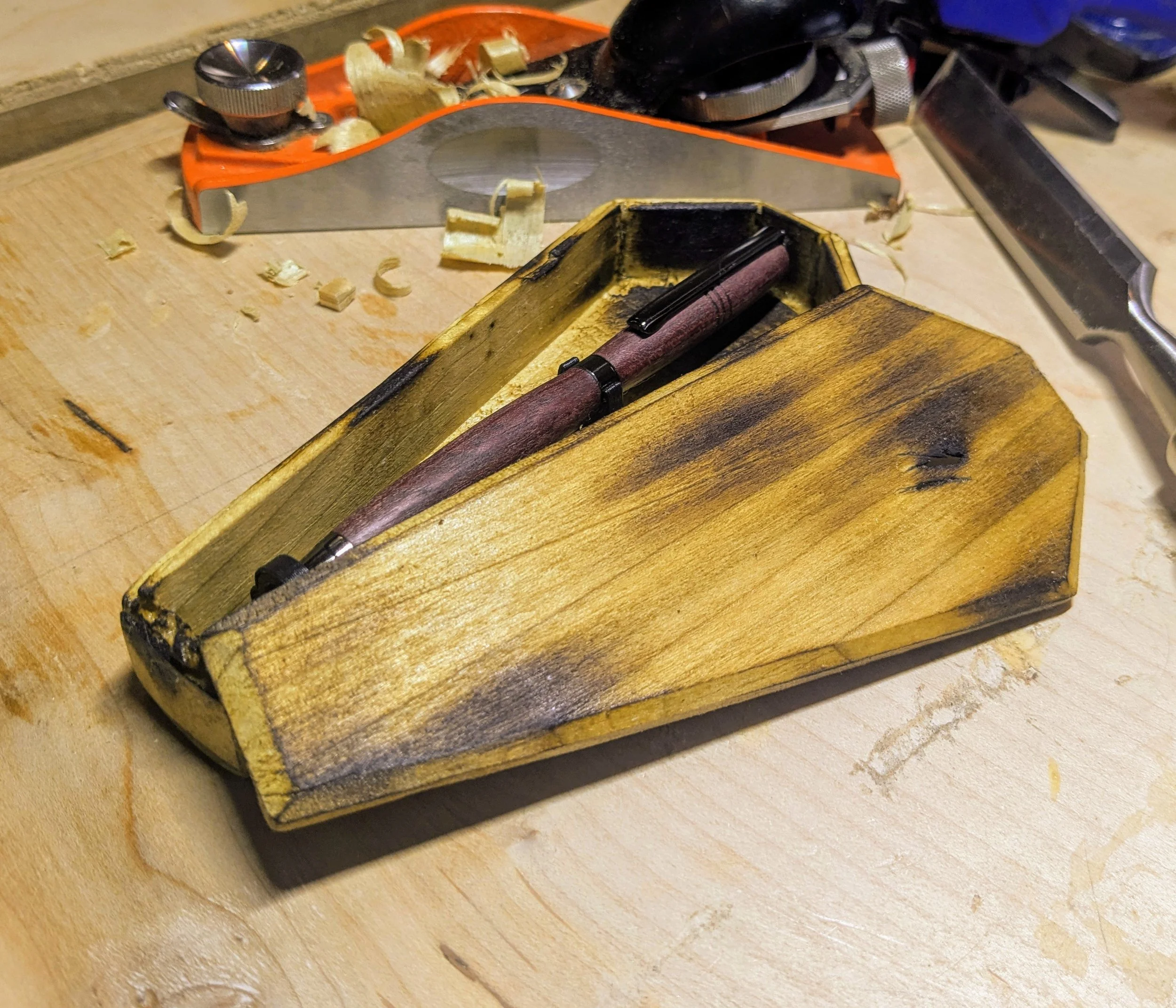 Purpleheart and Chrome Black Pen in a custom Coffin Box made from charred poplar.  This box was designed to tell a story, not just house a writing utensil.  The ink may run out, but the pen itself is undead!