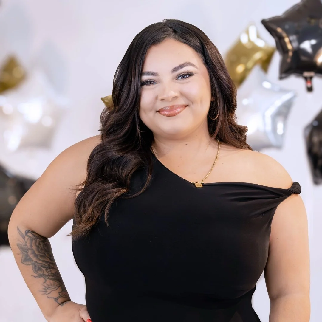 Woman with long curly hair smiling in a salon.
