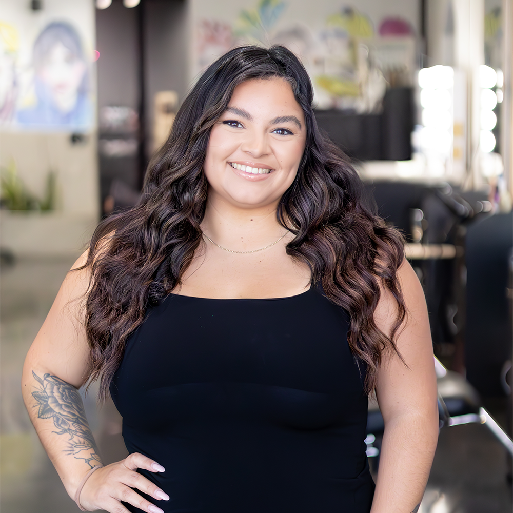 Woman with long curly hair smiling in a salon.