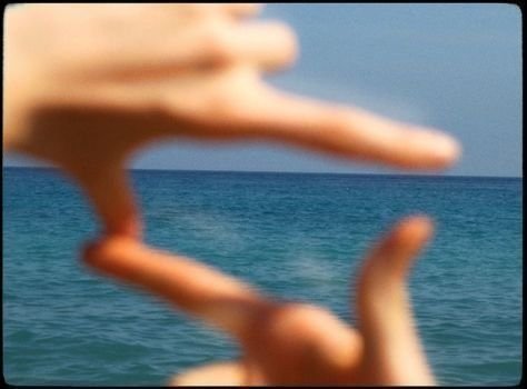 Blurred hands framing the ocean and sky