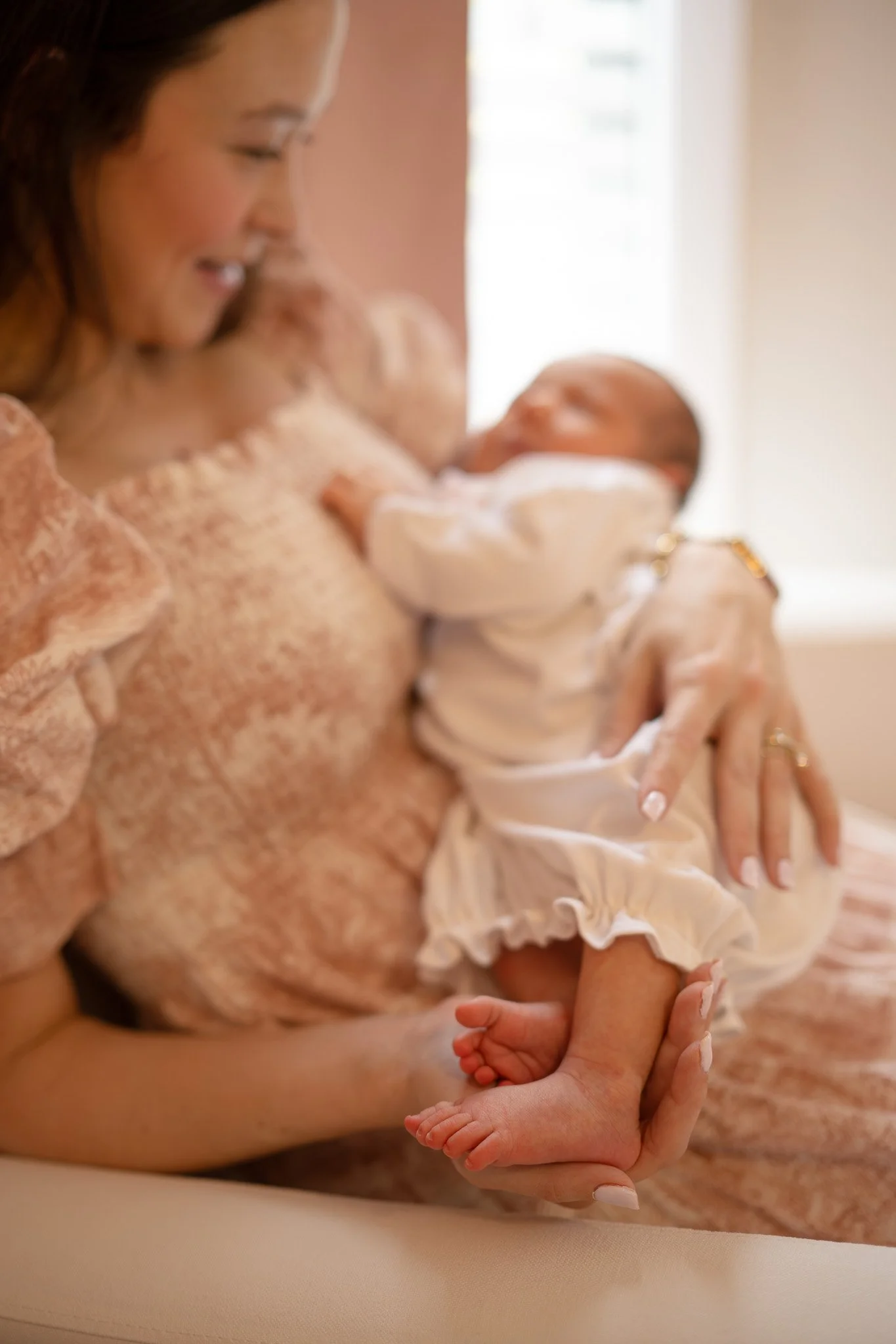 mom holding newborn baby toes at home in houston