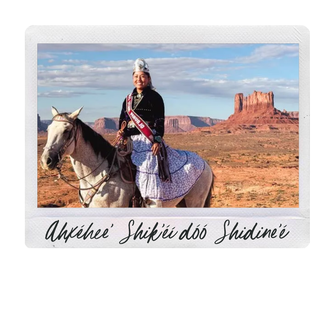 Person riding a white horse in a desert landscape with rock formations in the background