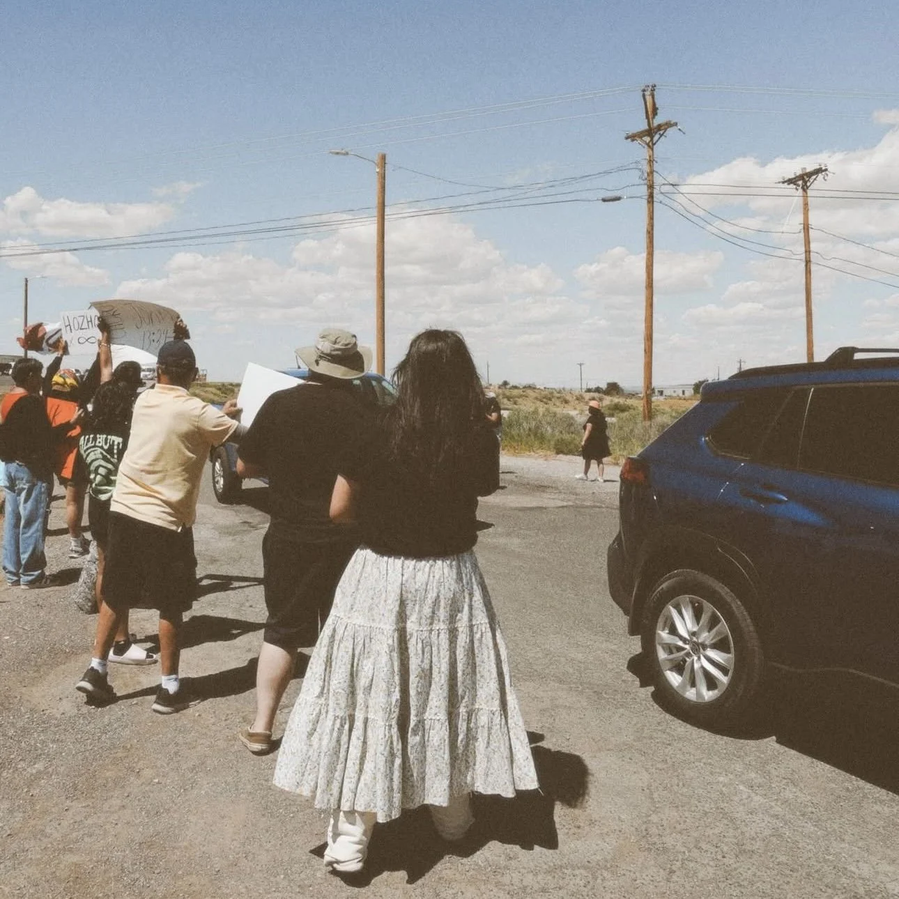 Louvannina Tsosie- Activist, has her group of people protesting on a rural roadside, holding signs and banners, in front of The Door Christian Fellowship in Gallup, NM.