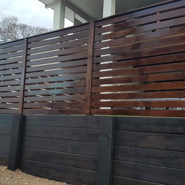 Timber fence installed above concrete retaining wall in Sydney