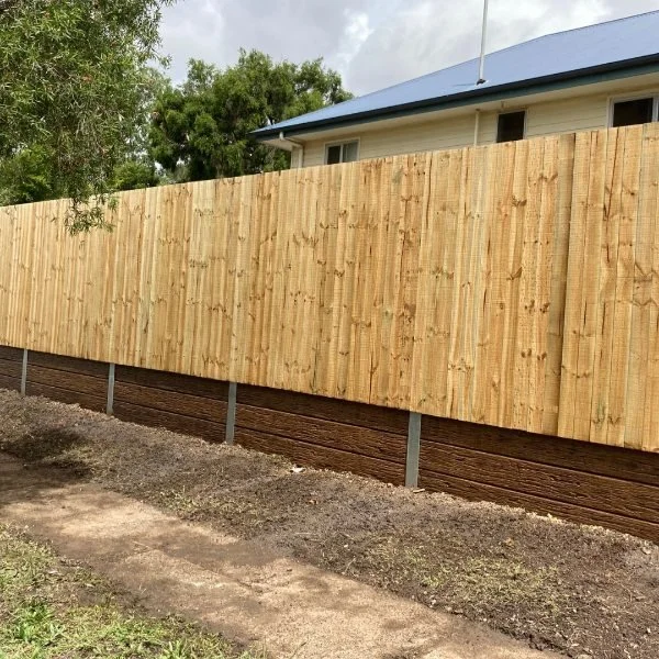 Timber paling fence above concrete retaining wall suburban Sydney