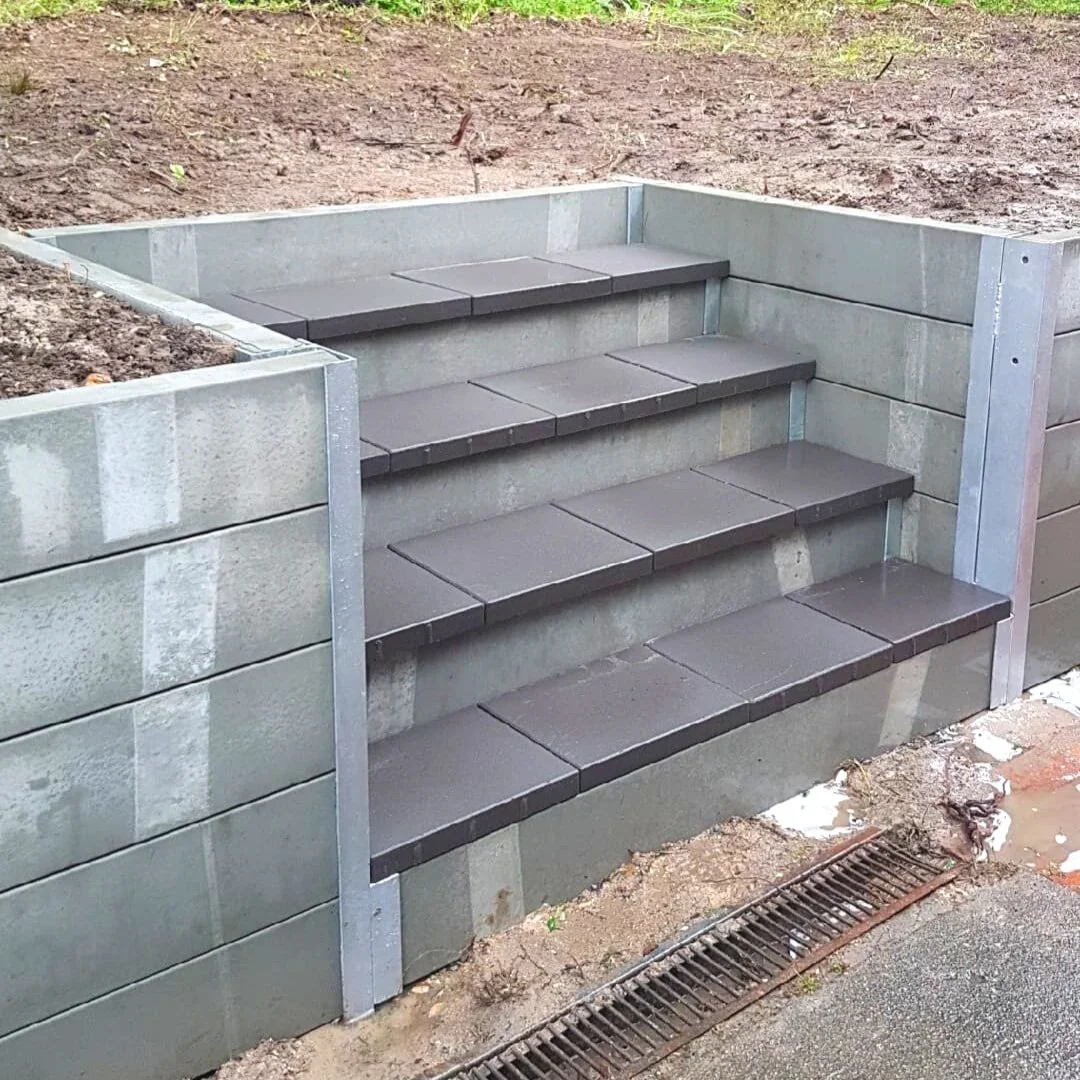 Concrete sleeper retaining wall with integrated steps in Sydney backyard