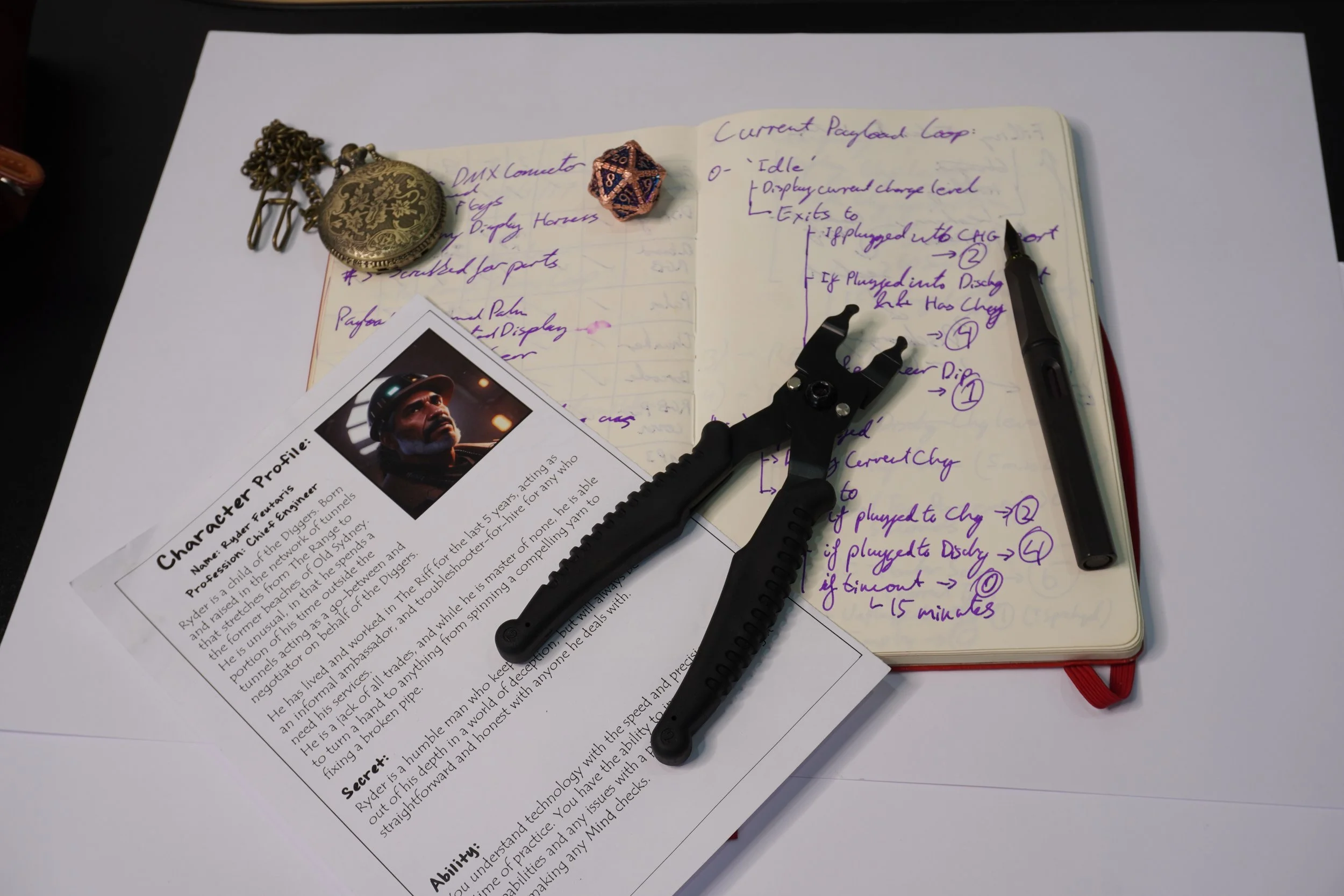 Desk with a character profile sheet, a notebook with handwriting, a pen, and some props.