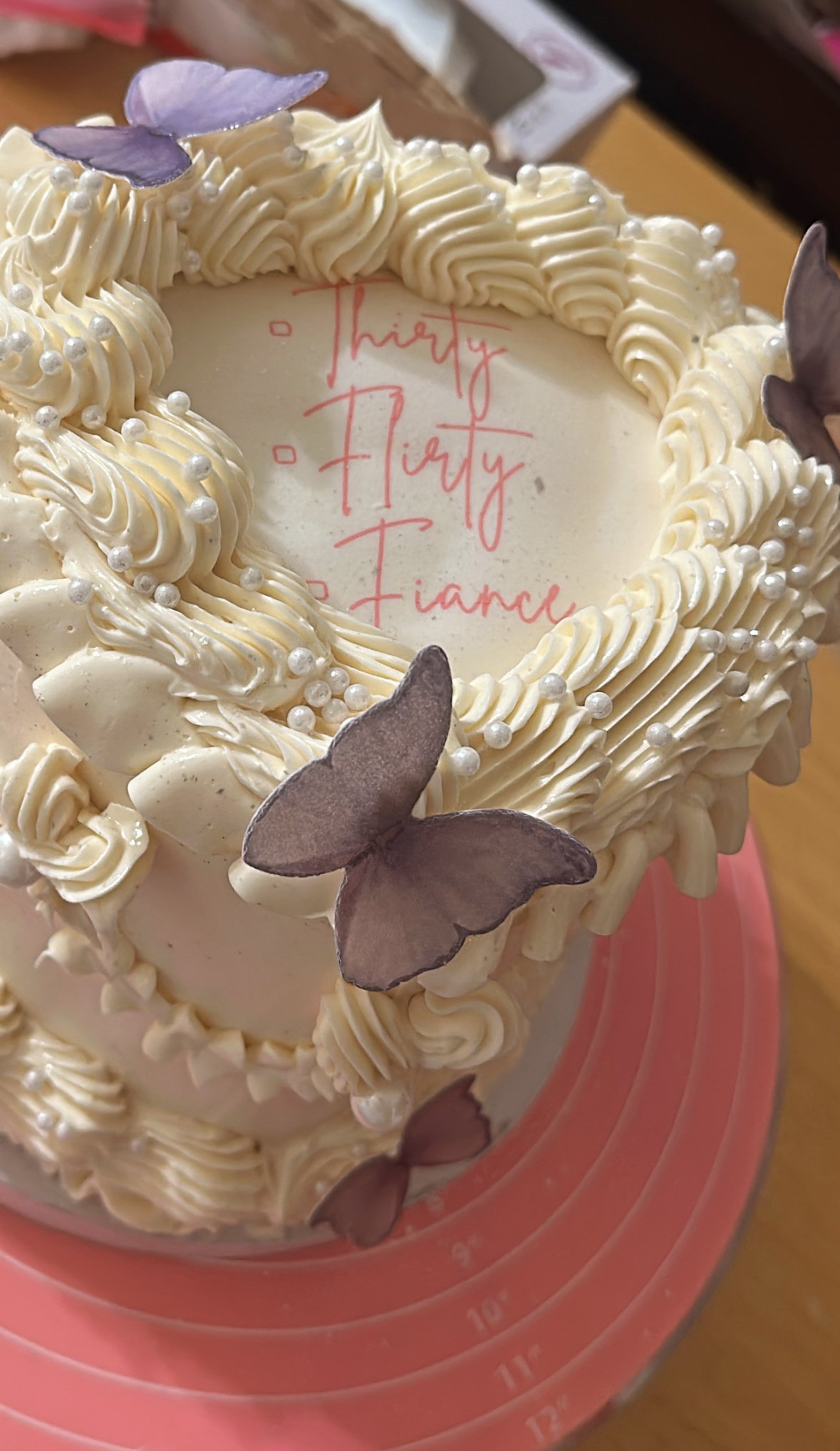 Heart-shaped ‘Thirty, Flirty, Fiancé’ celebration cake with vintage buttercream piping, pearl accents, and delicate purple butterflies — custom design by Twice As Sweet OC in Huntington Beach