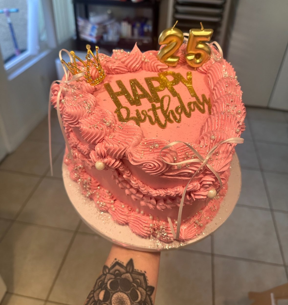 Pink heart-shaped vintage buttercream birthday cake with piped ruffles, pearl accents, gold sparkle details, and ‘25’ topper — custom design by Twice As Sweet OC in Huntington Beach