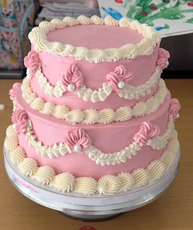 “Vintage-inspired pink and white buttercream cake with classic piped garlands, pearl details, and tiered retro design — handcrafted by Twice As Sweet OC in Huntington Beach