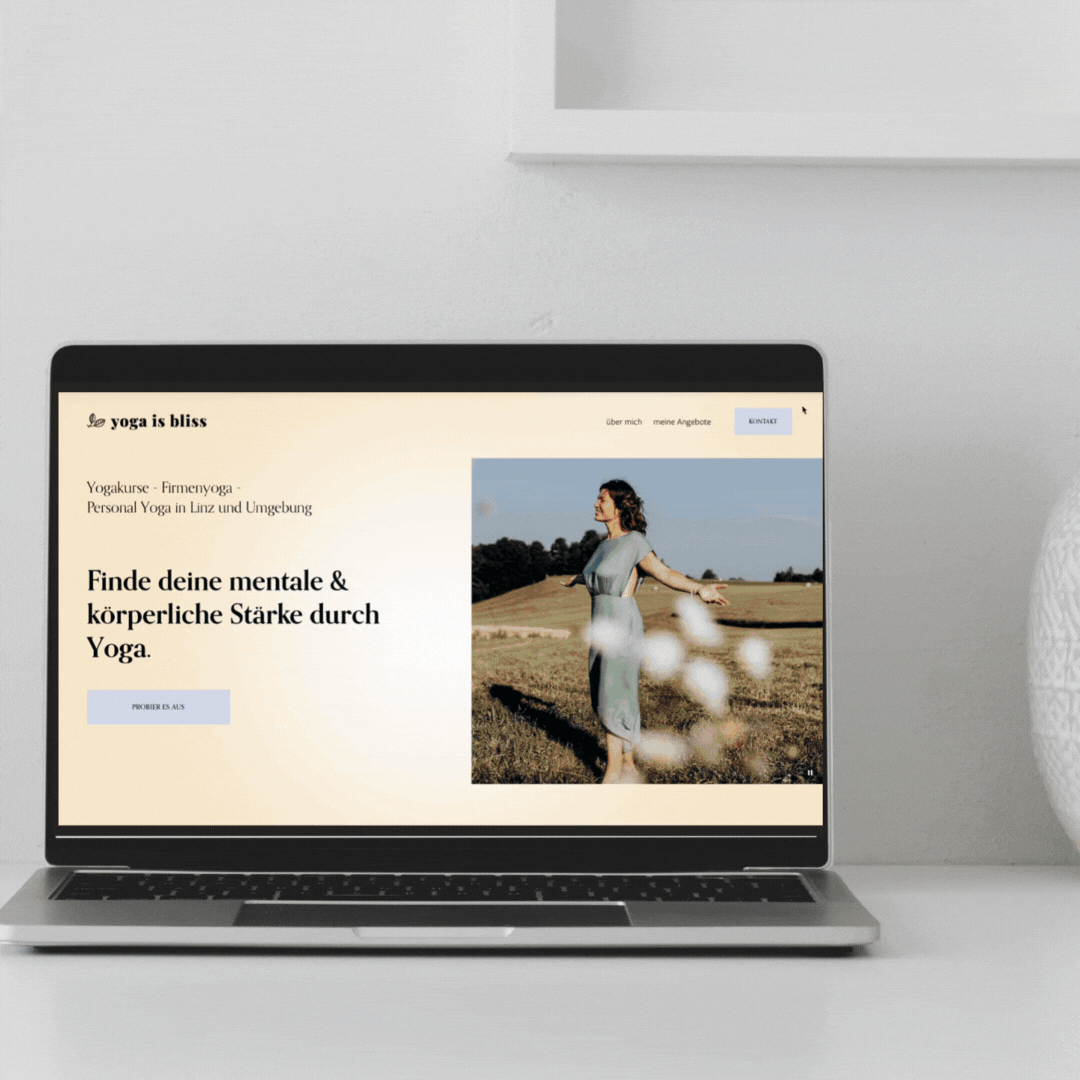 Laptop zeigt eine Webseite, die "Yoga is bliss" genannt wird. Der Bildschirm zeigt eine Frau, die in einem Feld Yoga praktiziert. Text: "Finde deine mentale & körperliche Stärke durch Yoga." Es gibt Links zu Kursen und persönlichen Angeboten in Linz.
