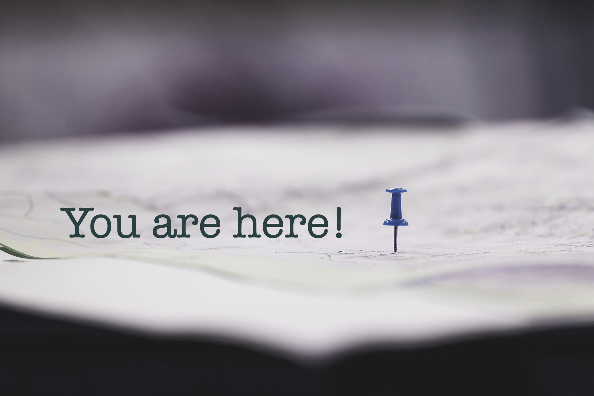 Eine Karte mit einem blauen Reißzwecken und der Aufschrift 'You are here!'