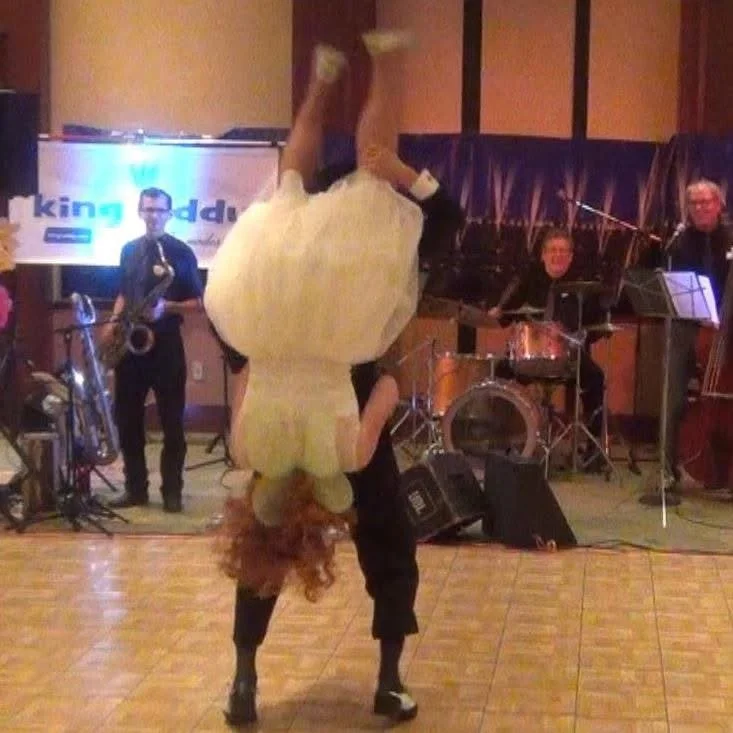Couple dancing energetically in front of a live band