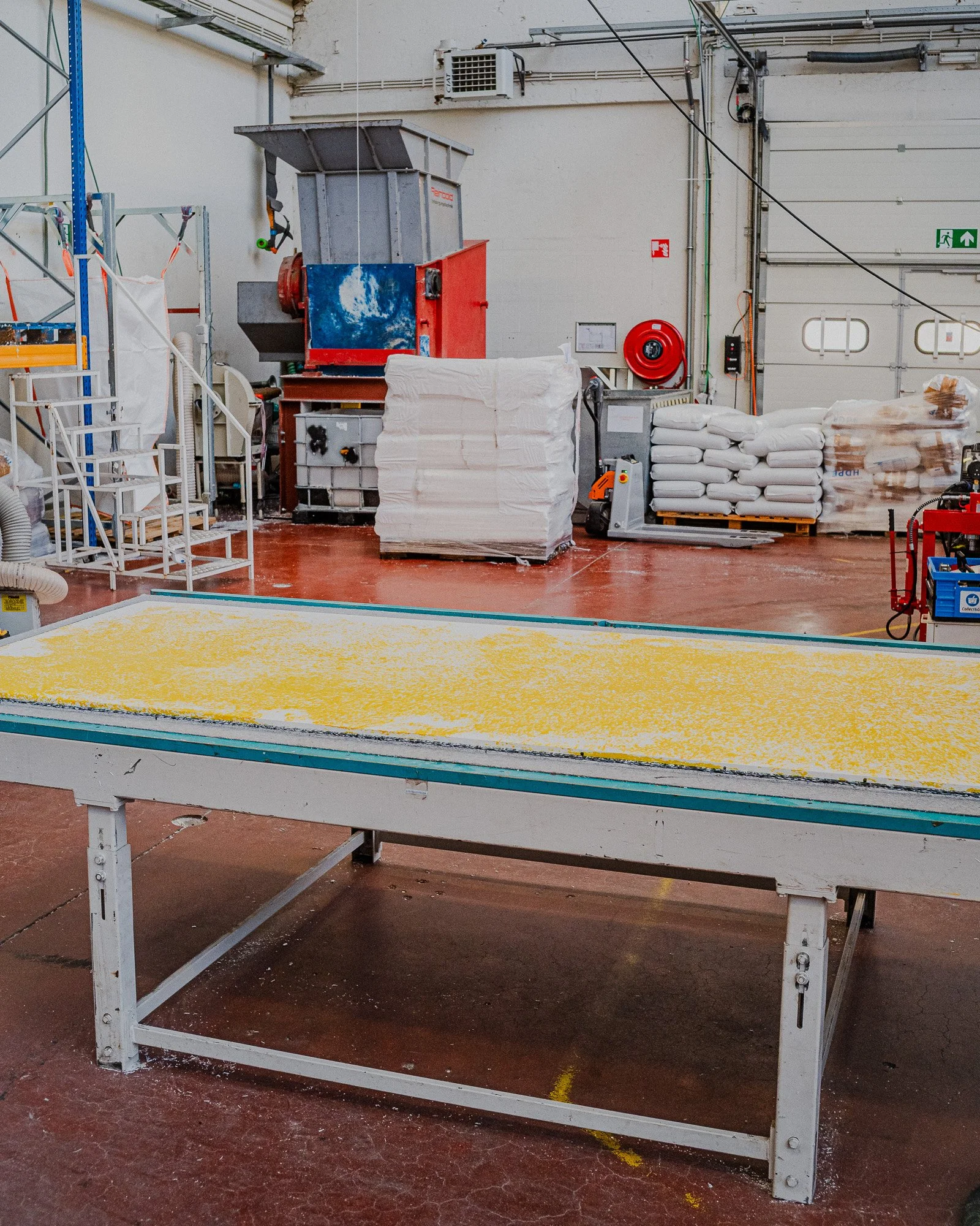 Panneau en plastique recyclé jaune et blanc déposé sur une table de travail dans un atelier industriel