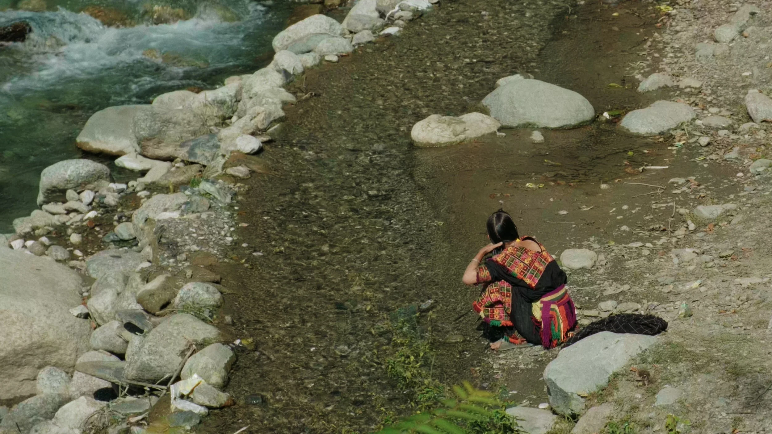 Kalash woman washing hair on the Riverside 