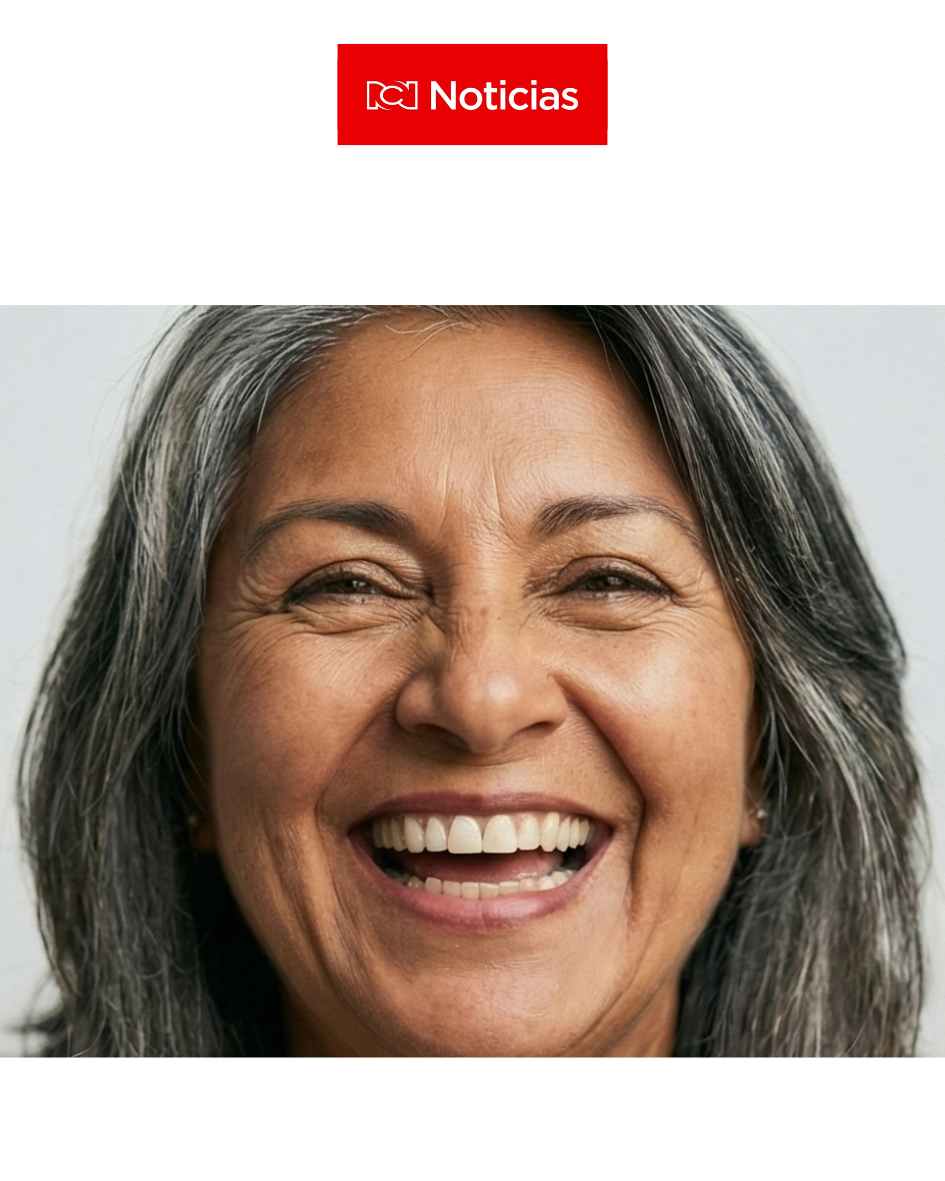 Mujer de cabello gris sonriendo felizmente en una foto de retrato.
