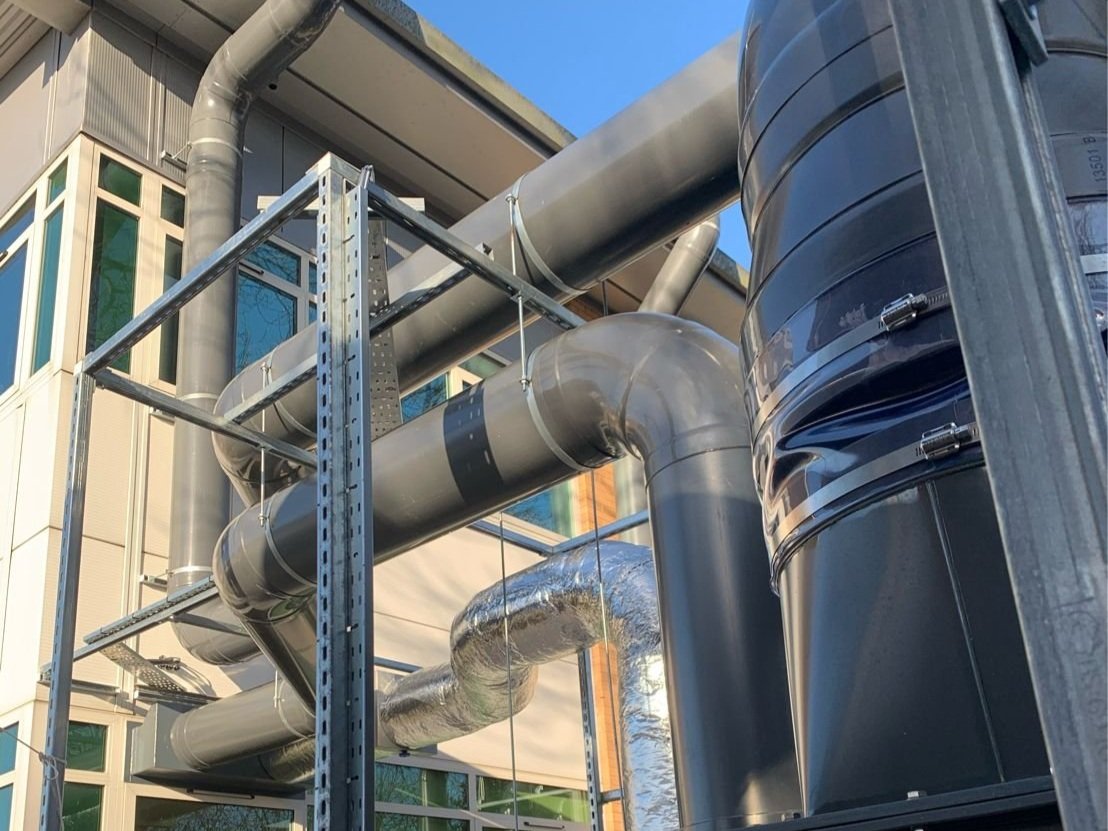 Outdoor industrial piping and ductwork connected to a building