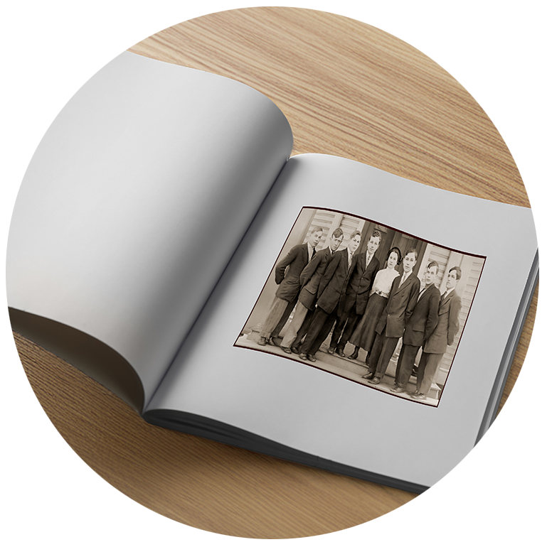 Hardcover book open on table, with page showing vintage photo, suggesting what a custom book might look like.