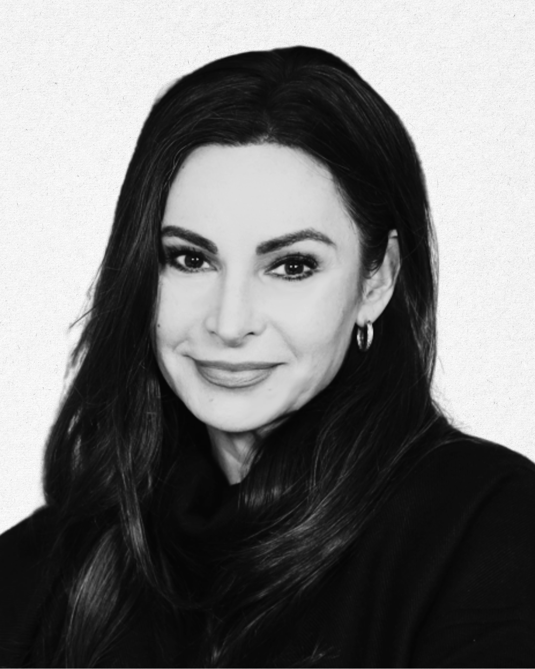 Black and white portrait of a woman with long wavy hair, wearing hoop earrings, smiling slightly, with a plain light background.