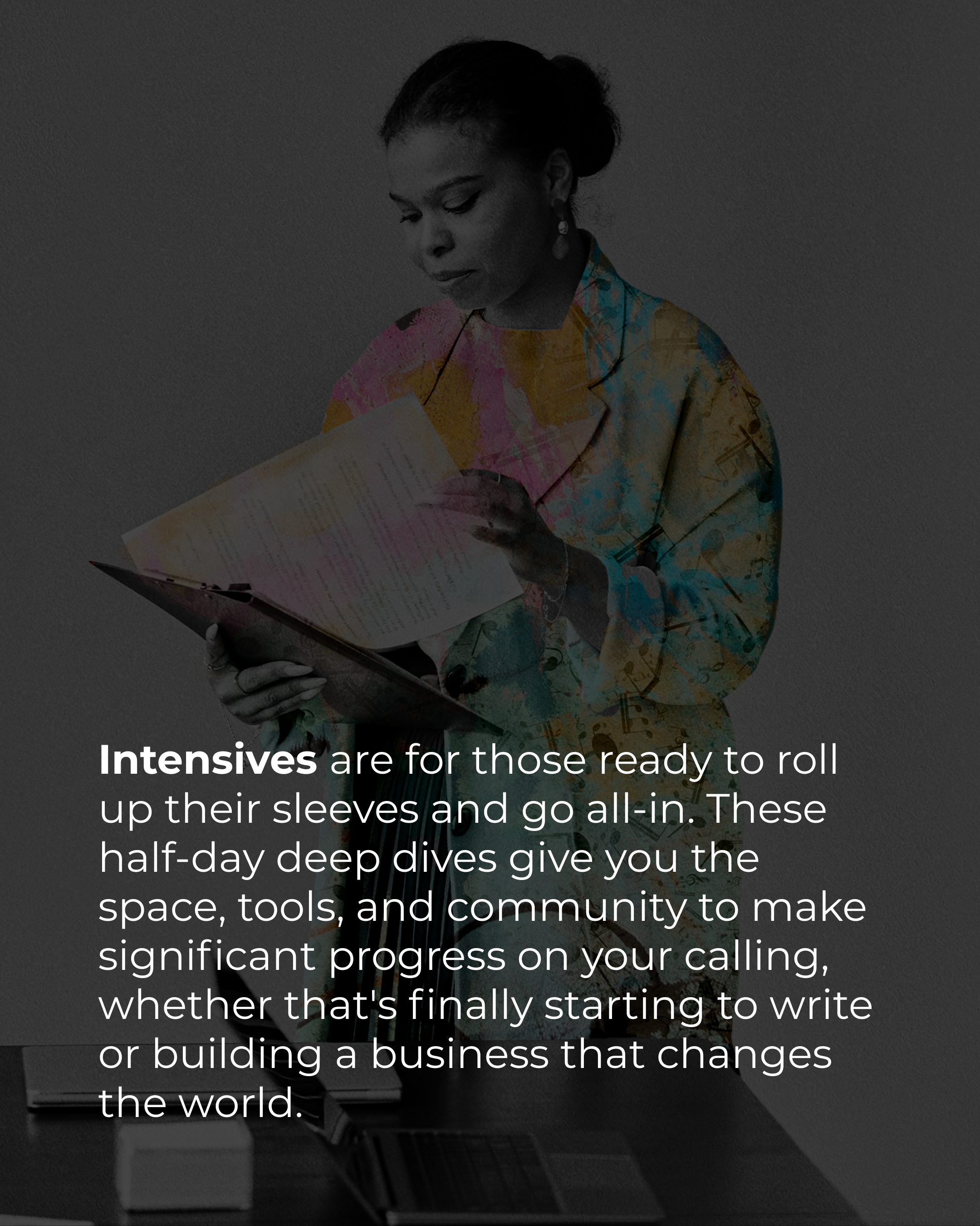 A woman dressed in colorful clothing reading a document while standing at a desk with a laptop, in a professional setting.