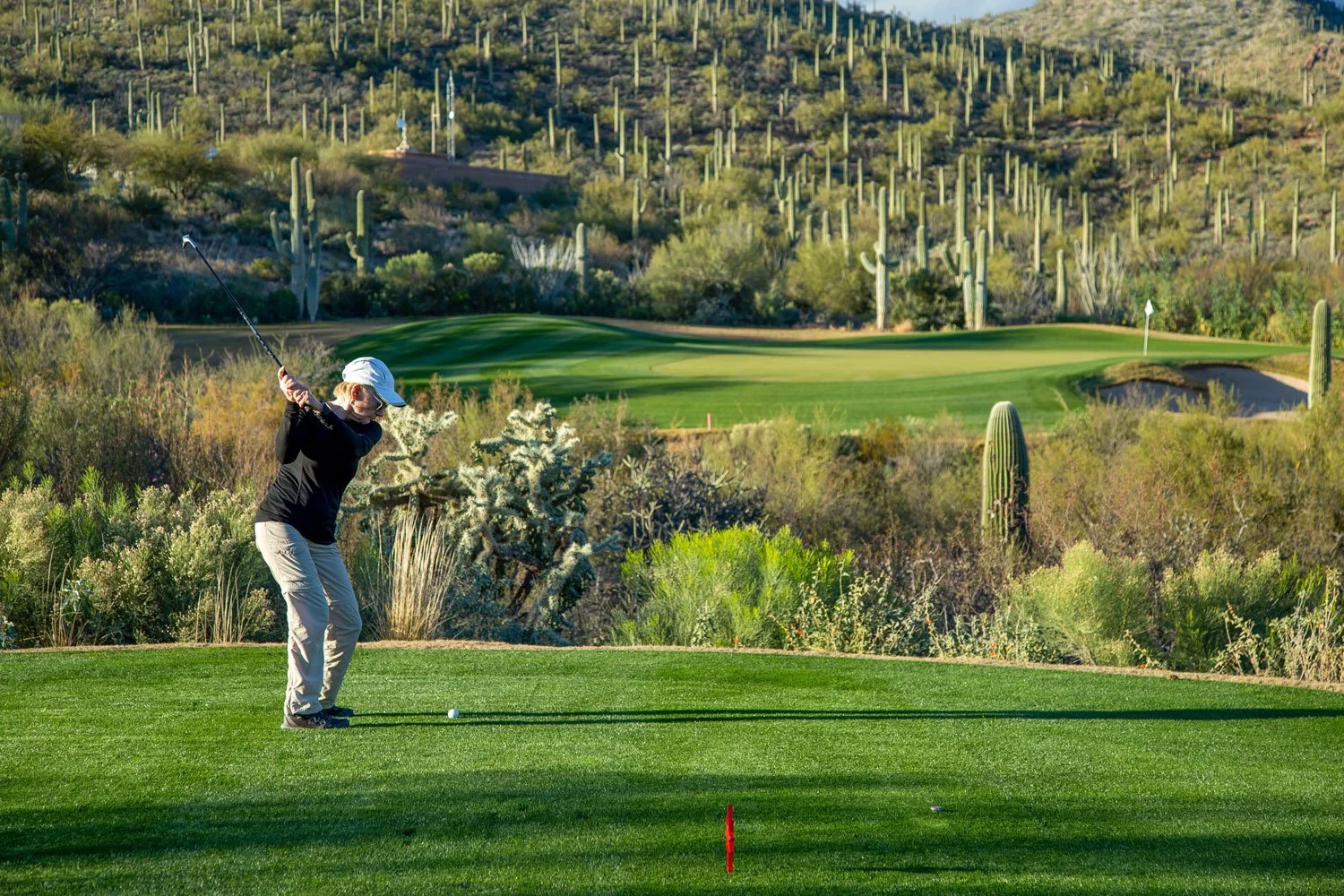 Person swinging a golf club at the Stone Canyon Club.