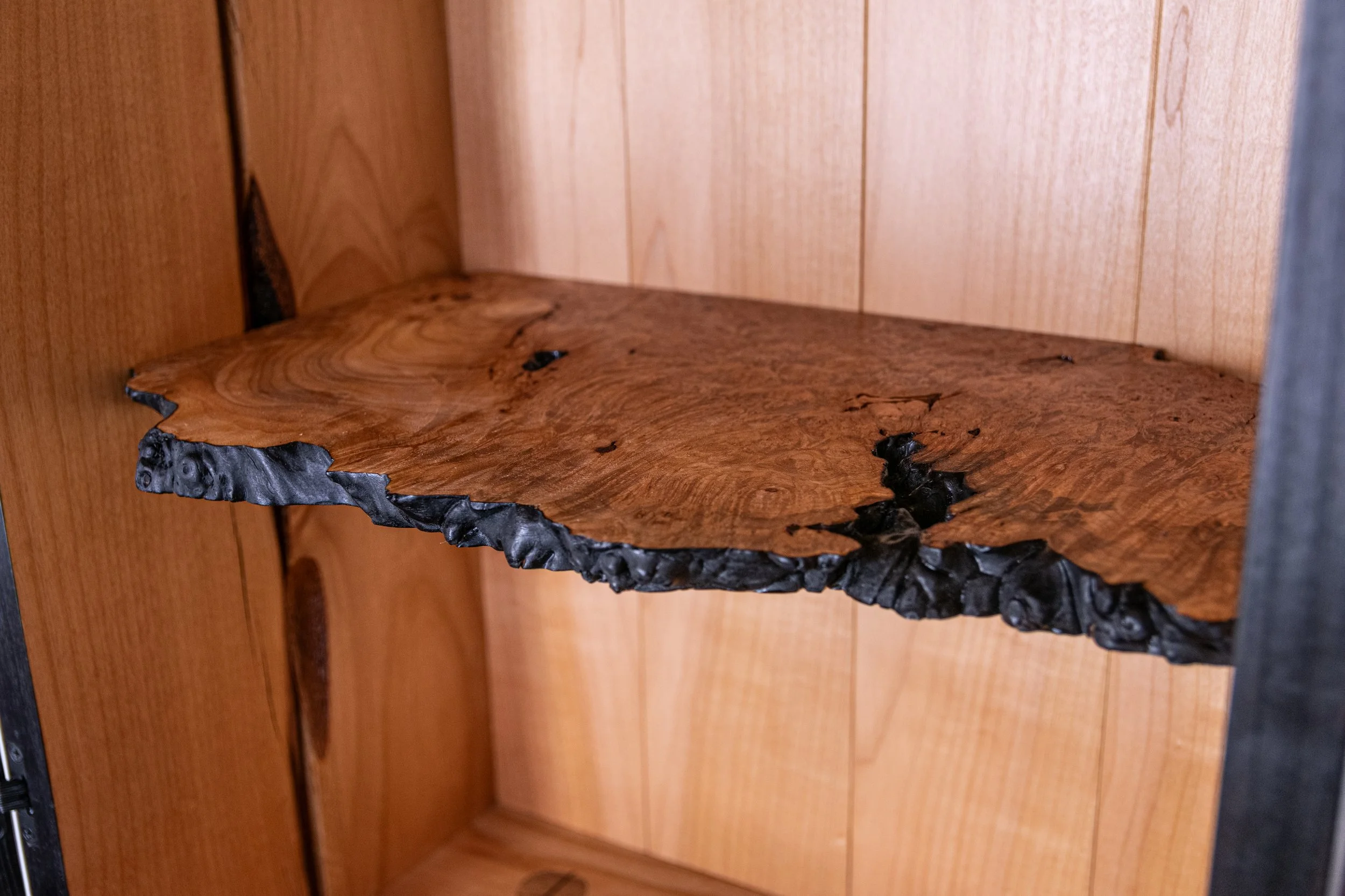 Interior detail shot of cabinet with maple burl shelving