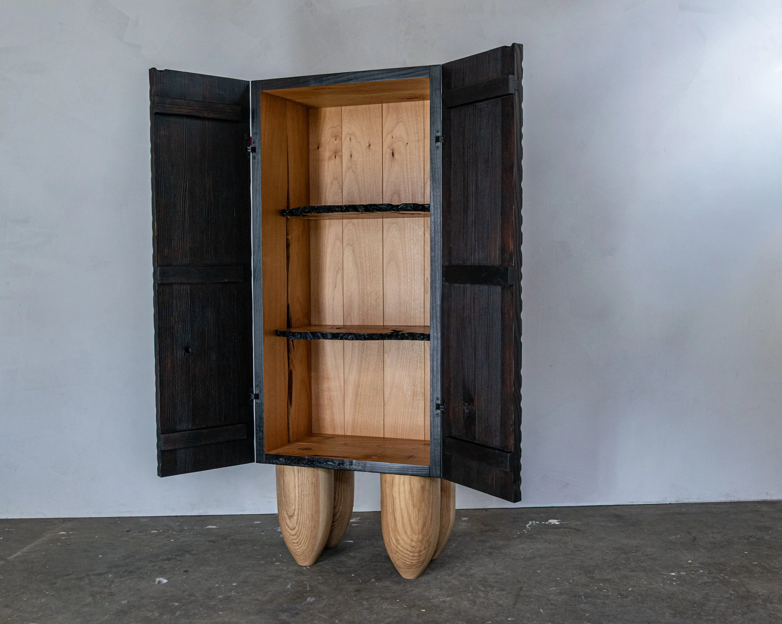 Display cabinet with doors open showing black exterior and warm wood tone interior