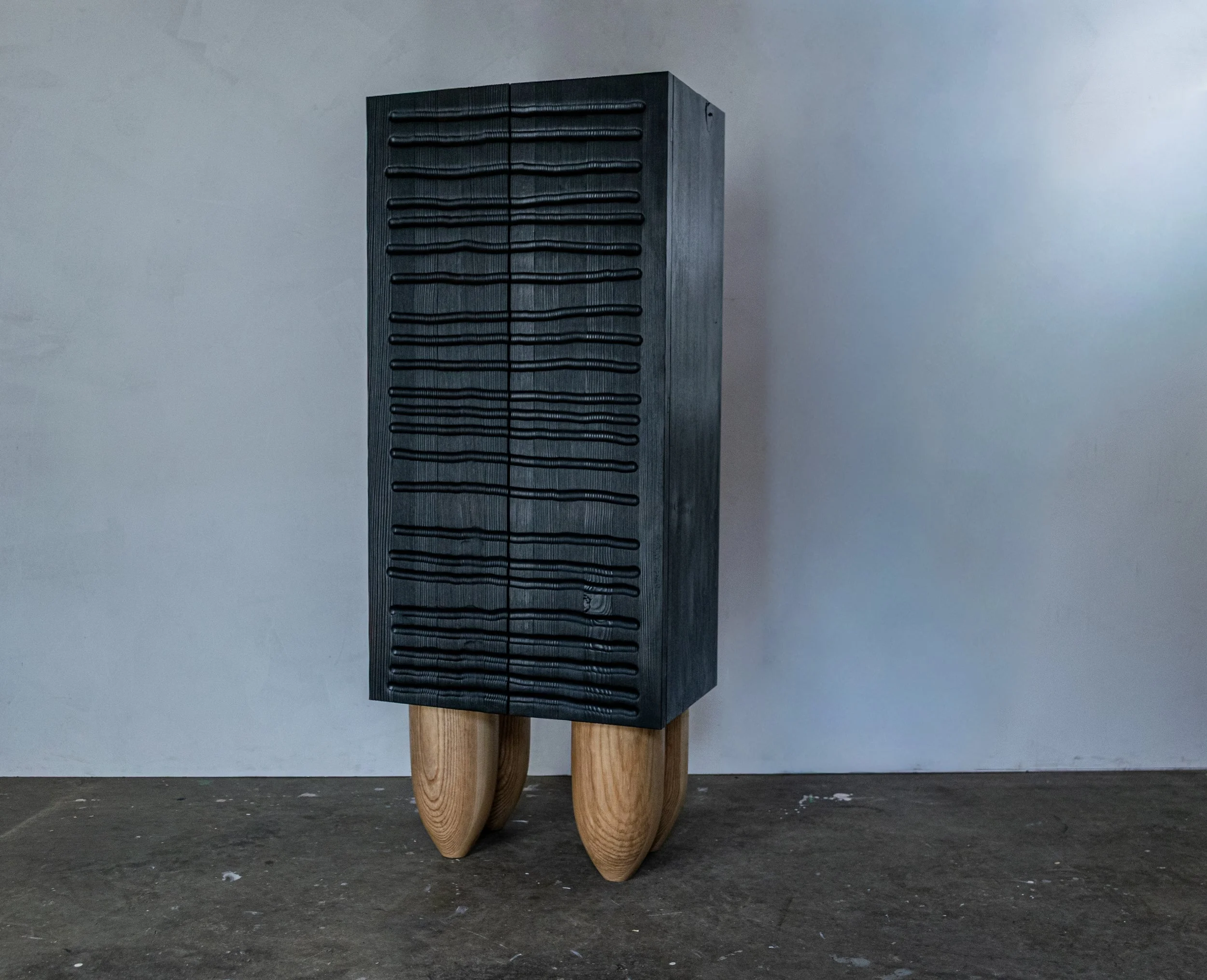 Black display cabinet featuring hand-carved doors.