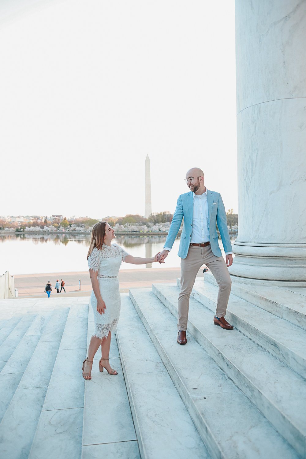 Couple holding hands on steps near Washington Monument