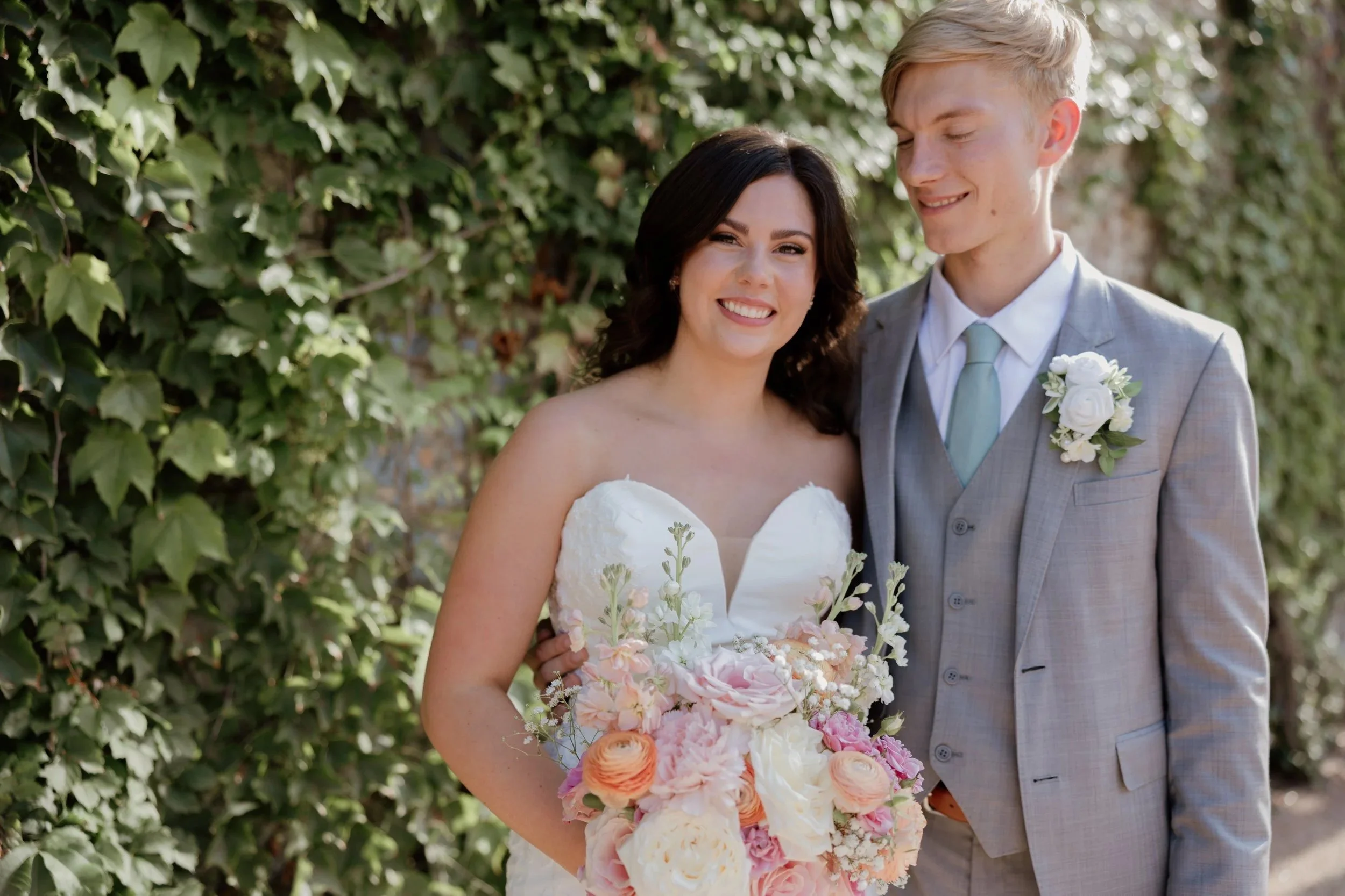 bride and groom standing by an ivy wall at their Fort Worth wedding