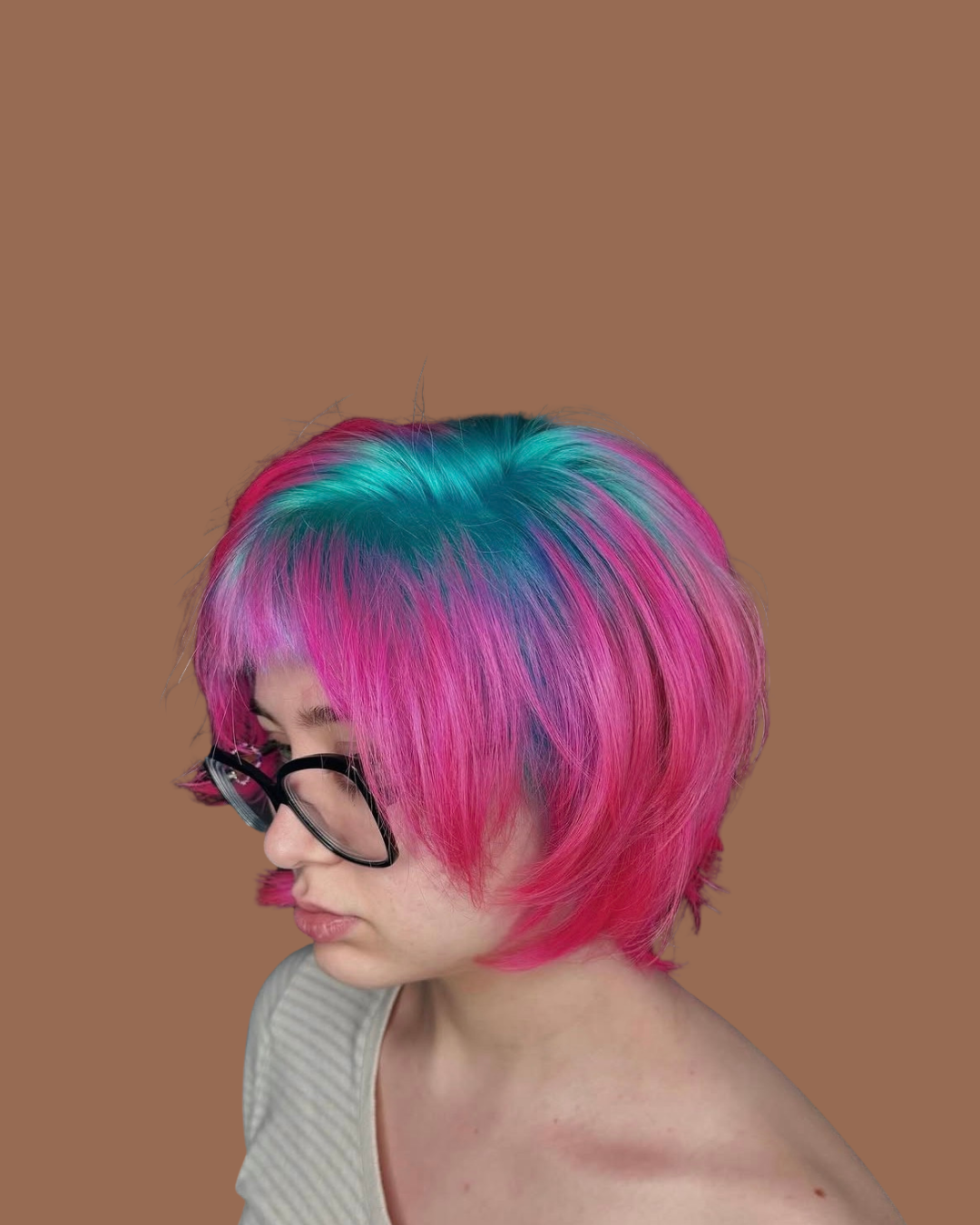 person with short blue and pink hair and glasses