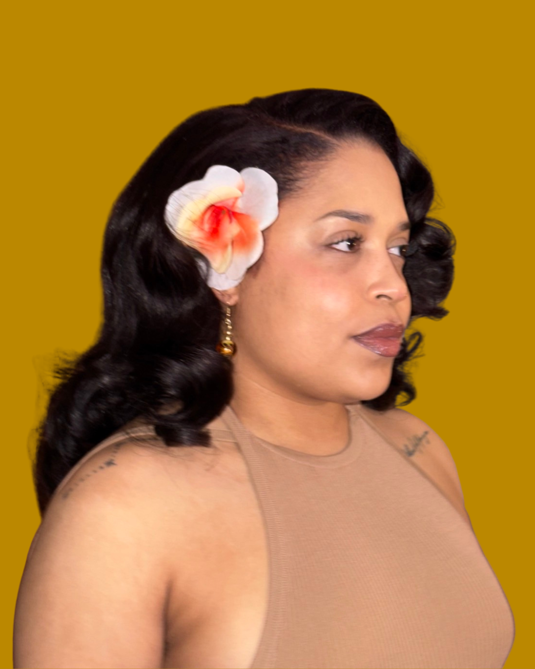 person with long black hair styled with bright pink flower