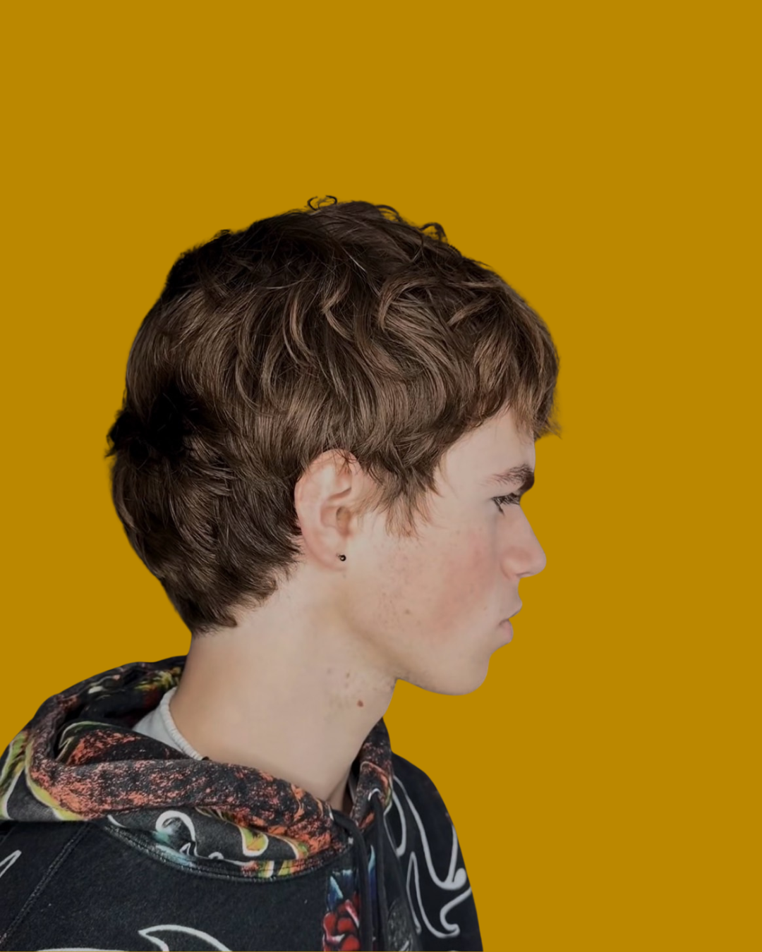 person with short brown hair and colorful hoodie